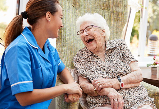 a senior woman smiles with her physical therapist