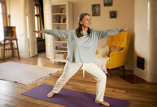 a woman does yoga as part of her parkinson's physical therapy program